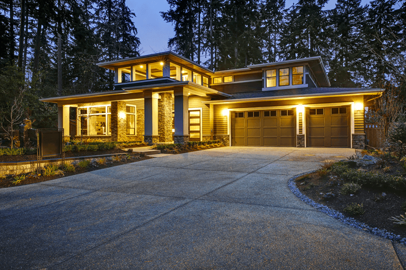 Exterior of large single family home in evening with tress